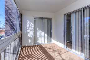 A balcony with a metal railing and a sliding glass door.