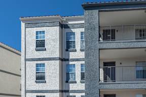 A tall building with a balcony on the top floor.
