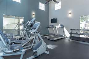 A gym with treadmills, exercise bikes, and elliptical machines.