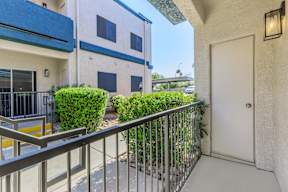 A balcony with a white door and a metal railing.