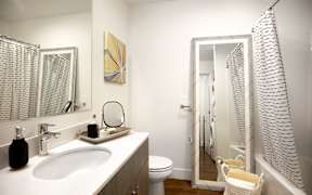 A bathroom with a white sink and a white toilet.