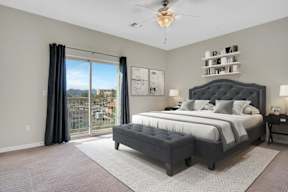 A bedroom with a large bed and a view of the city.