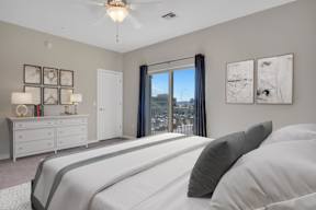 A bedroom with a large bed and a view of the city.