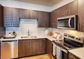 A modern kitchen with wooden cabinets and stainless steel appliances.