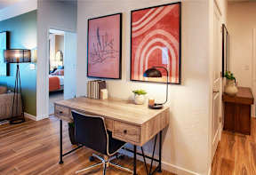 A desk with a chair and a lamp in a room.