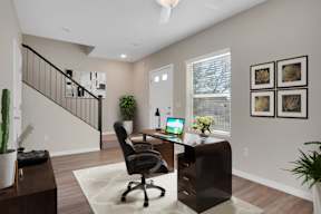 A home office with a desk, chair, and a laptop.