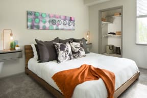 a bedroom with white bedding and an orange blanket