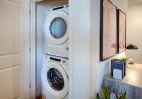A white washing machine is in a small room.