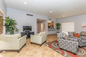 A living room with a large couch, a chair, and a television.