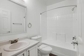 A white bathroom with a toilet, sink, and bathtub.