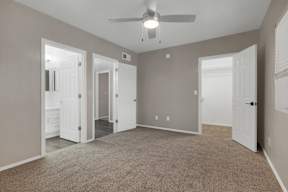 A room with a ceiling fan and carpeted floor.