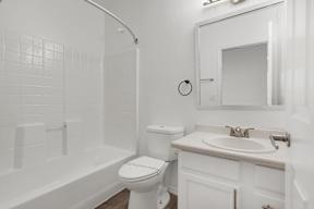A white bathroom with a toilet, sink, and tub.