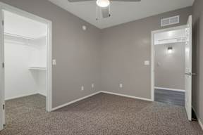 A room with a ceiling fan and two doors.