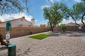 A backyard with a green lawn and a sign that says "No Parking".
