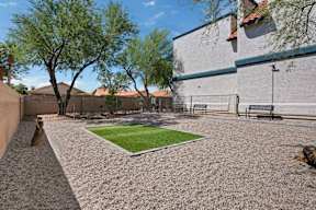 A backyard with a small grass area and a gravel path.