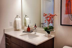 A bathroom with a white sink and a mirror.