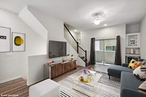 A living room with a grey couch and a white coffee table.