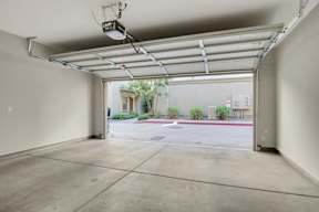 A large, empty garage with a view of a parking lot and a building outside.