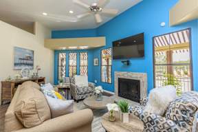 A living room with a fireplace and a television on the wall.
