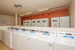 A laundromat with rows of washers and dryers.