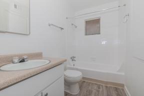 A white bathroom with a sink, toilet, and bathtub.