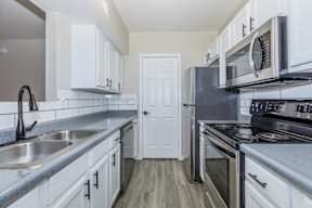 A kitchen with white cabinets and stainless steel appliances.