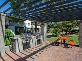A patio with a table and chairs under a pergola.