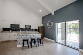 A kitchen with a bar stool and a clock on the wall.