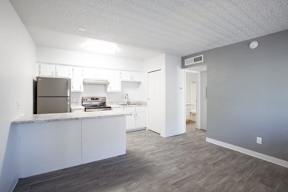 A kitchen with white countertops and a stainless steel refrigerator.