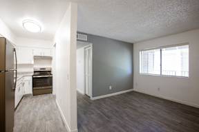 A kitchen with a refrigerator, oven, and sink.
