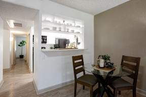 A dining room with a glass table and chairs.