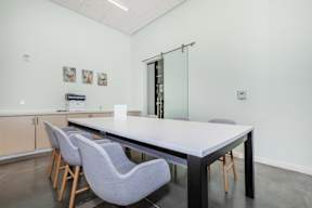 A conference room with a long table and chairs.