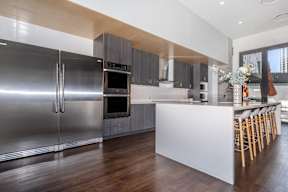 A modern kitchen with a white island and stainless steel appliances.