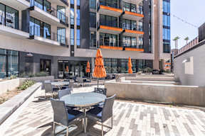 A modern building with a patio area in front.
