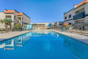 A swimming pool in a residential area with buildings in the background.