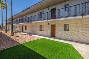 A building with a balcony and a green lawn in front.at Icon Apartments, Tucson Arizona