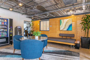 A modern office space with a wooden accent wall and blue chairs.