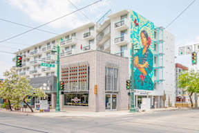 A street view of a building with a large mural on the side.