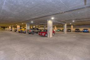A parking garage with several cars parked in it.