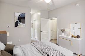 A bedroom with a bed, dresser, and mirror.