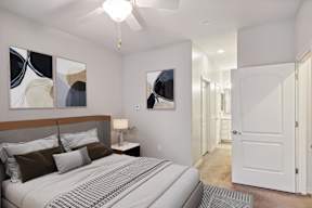 A bedroom with a large bed and a ceiling fan.
