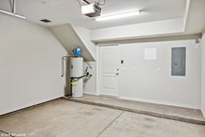 A room with a white door, a white wall, and a white ceiling.