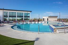 A large outdoor swimming pool with a building in the background.
