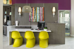 an office with purple walls and a desk with three yellow chairs