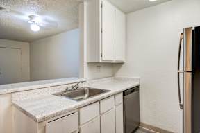 A kitchen with white cabinets and a granite countertop.