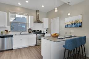 A modern kitchen with white cabinets and a large island.