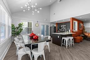 a dining room and kitchen area with a table and chairs