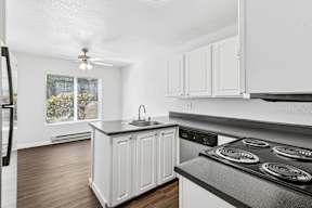 A kitchen with white cabinets and a black stove top.