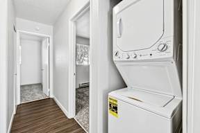 A white dryer is in a small room with a door open.