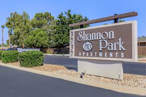 A brown sign that says Shannon Park Apartments.
